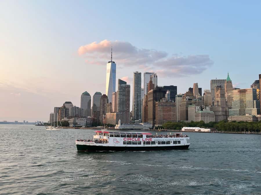 NYC: Statue of Liberty Sunset Cruise Skip-the-Line Ticket - Brooklyn Bridge, Manhattan, and the lights coming on
